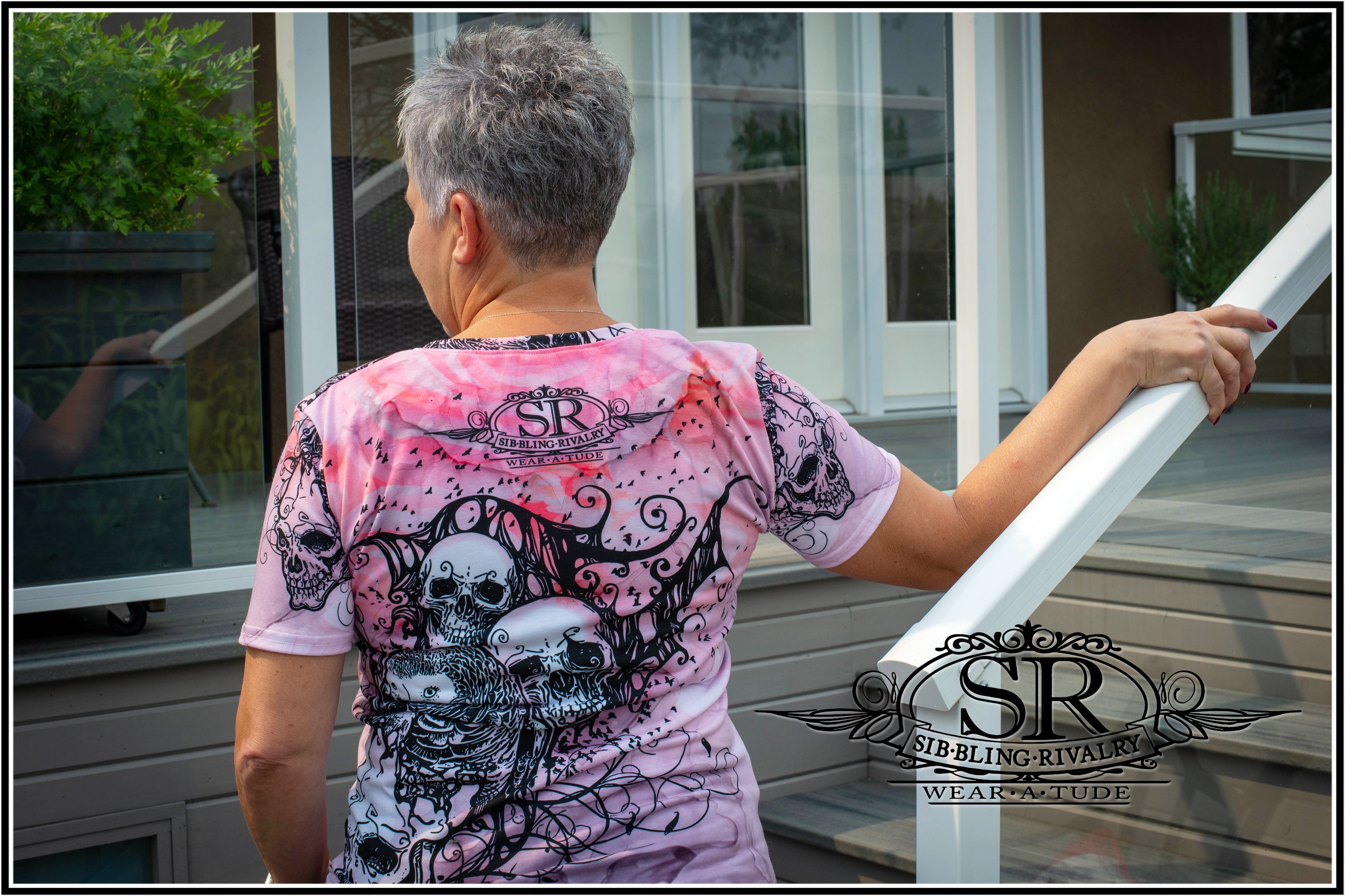 Mature tough gal taking a break from riding as she shows off the back of her extremely cool pink skull shirt. She has her WEAR A TUDE on.