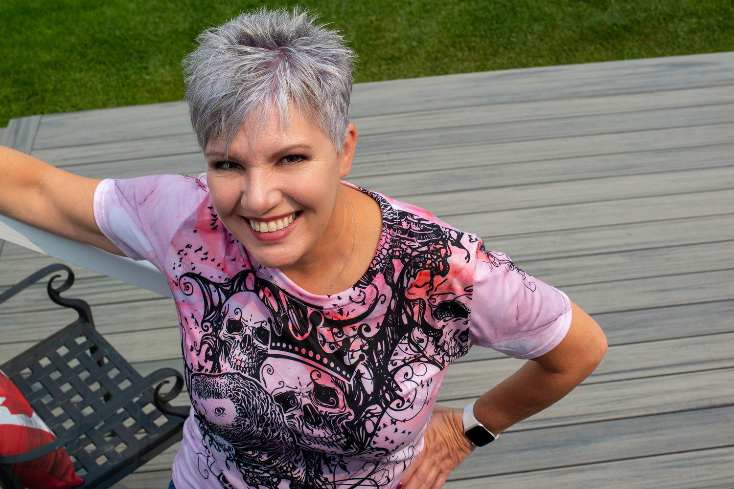 Beautiful mature woman wearing our Pink Grey t-shirt in woman's cut. A wonderful mix of an African Grey Parrot, blank inky embellishments and a princess/queen skull. 